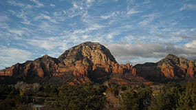 Sedona red rocks reach majestically into a cloudy sky