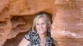 A woman is tucked away inside the hollow of a red rock on a Sedona Vortex Retreat