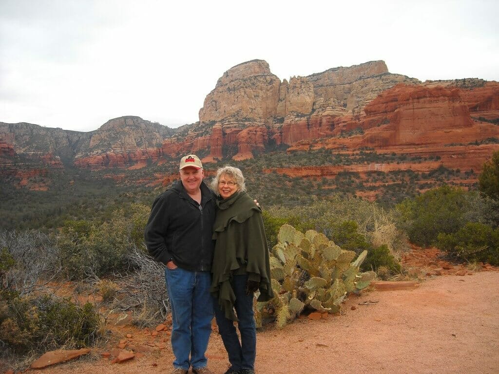 Couple posing in front of red rocks.