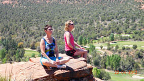 Sedona Vortex yoga retreat attendees hang out on the edge of a red rock overlooking Verde Valley